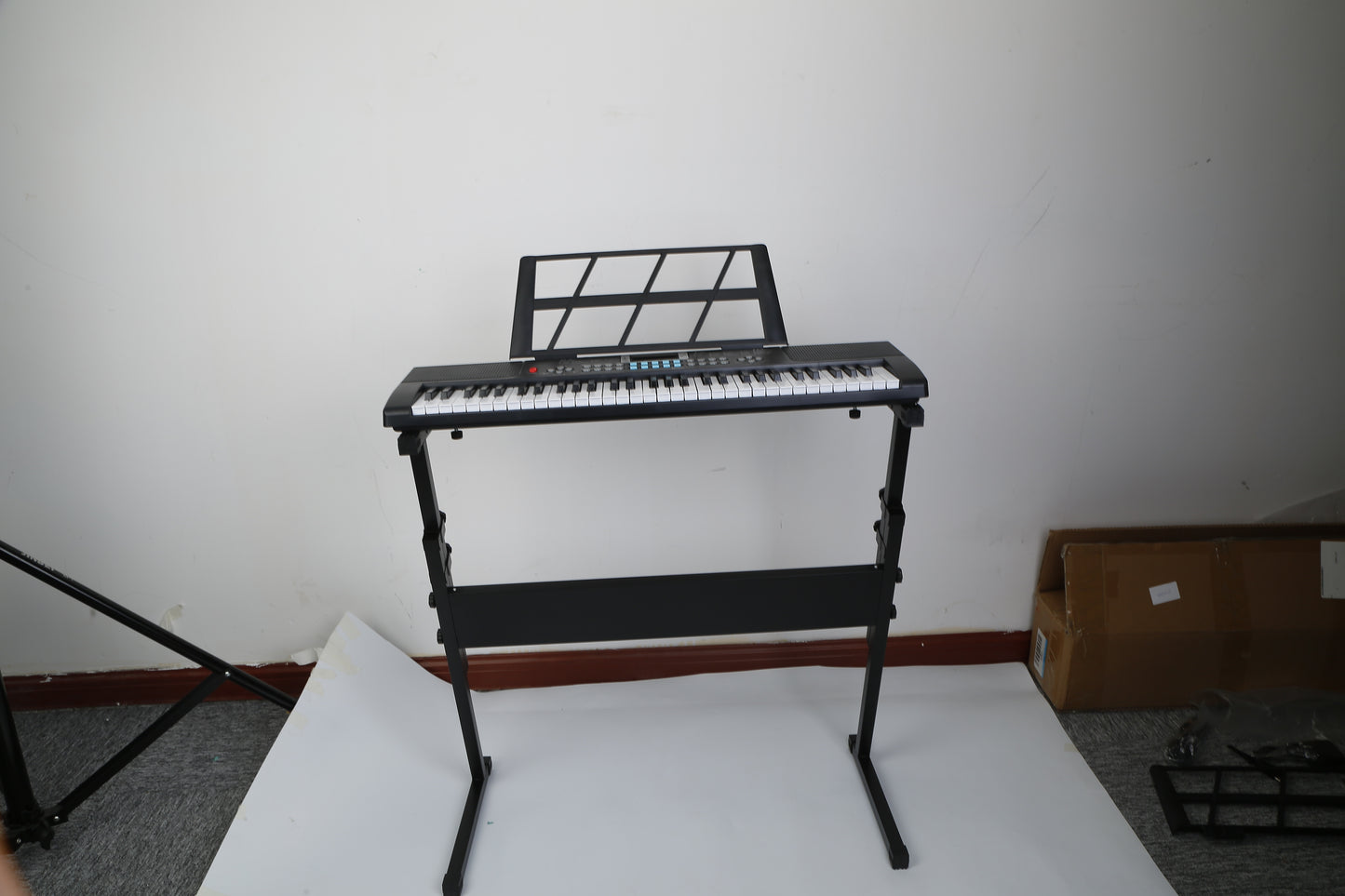 Electronic keyboard on a stand against a white wall