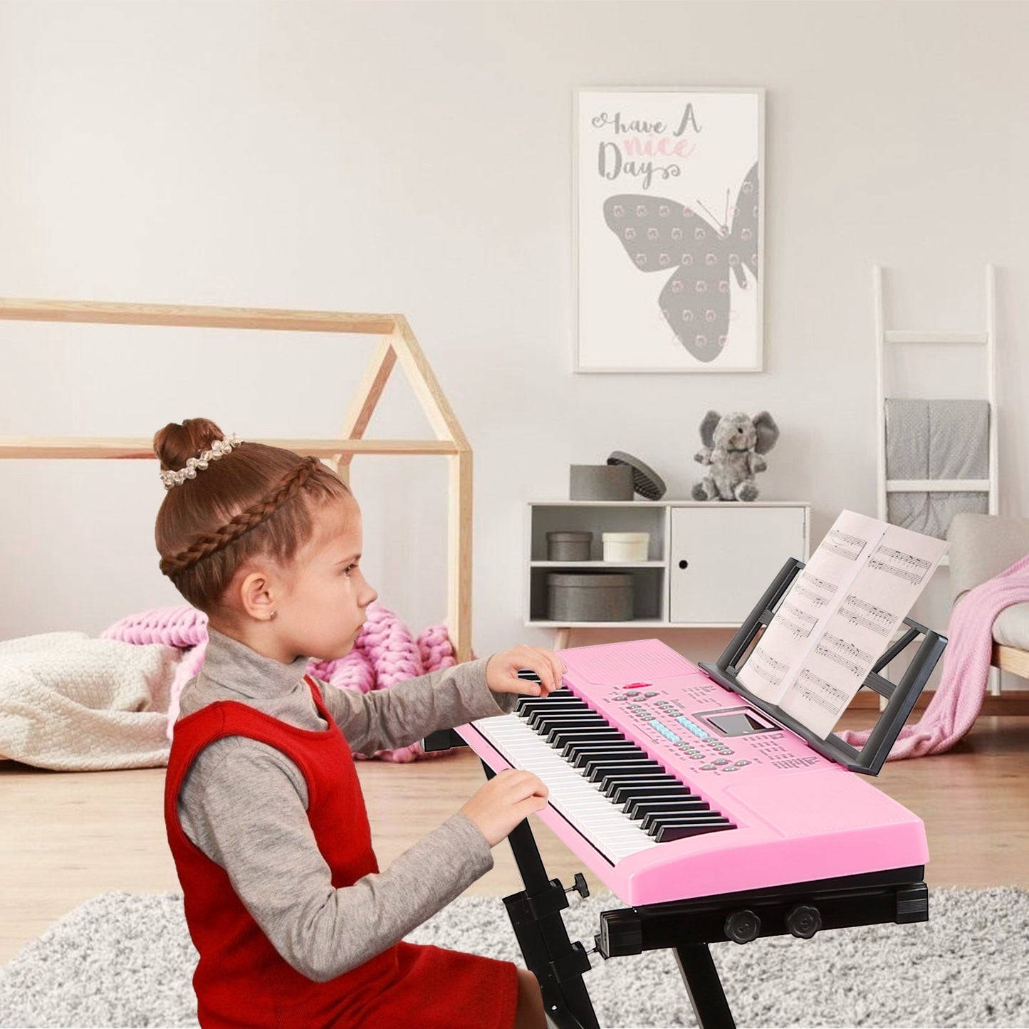 Child playing a pink toy keyboard in a room with a butterfly decoration on the wall.